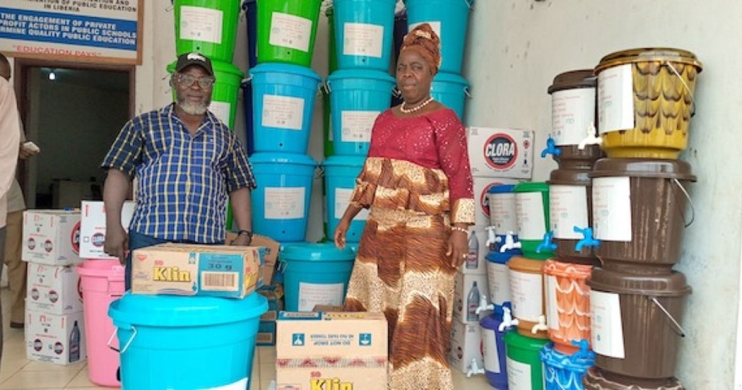 La presidenta de la NTAL, Mary W.M. Nyumah, entrega al director general de educación del condado de Montserrado, Samuel Bondo, material de protección personal para luchar contra la pandemia de COVID-19 en Liberia.