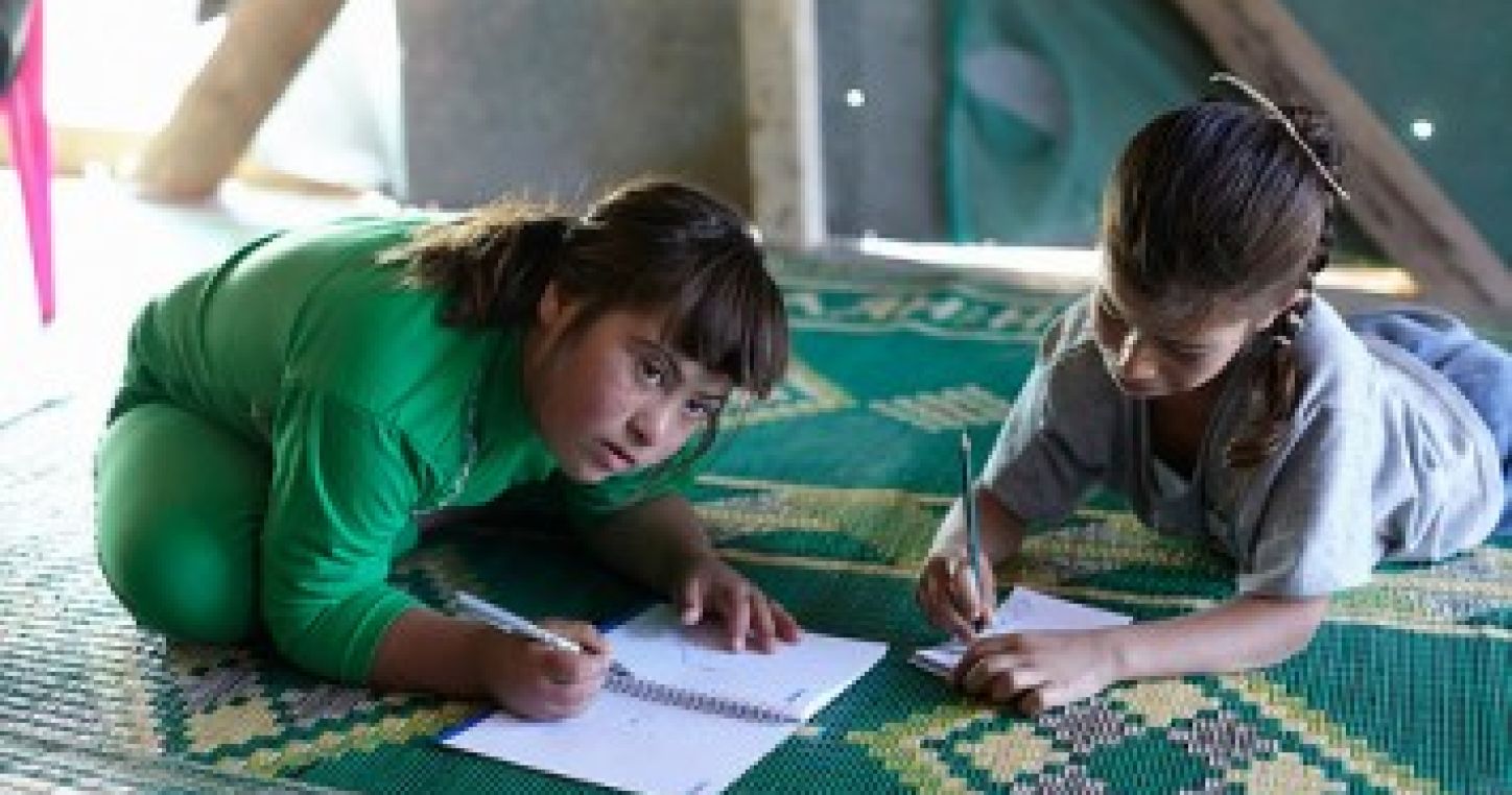 De jeunes filles réfugiées syriennes s'exercent à l'écriture chez elles dans un camp de réfugiés.  ©UNHCR