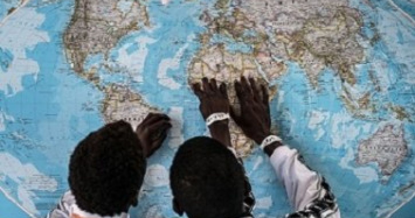 Gambian asylum seekers discuss their journey together while looking at a map on the wall at an asylum seeker reception centre in Sicily, Italy. © UNICEF/UN020011/Gilbertson VII Photo