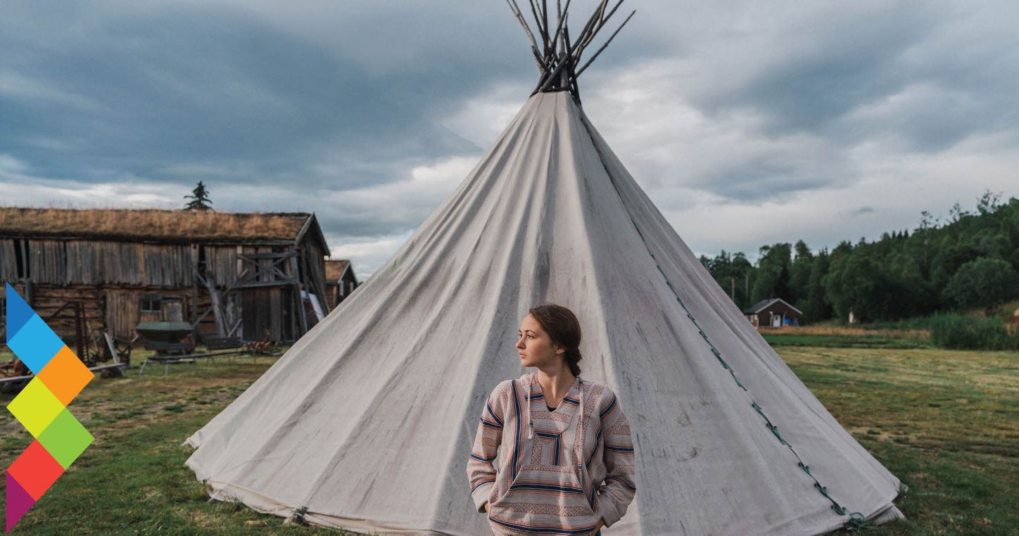 Young Sami woman in front of traditional tent