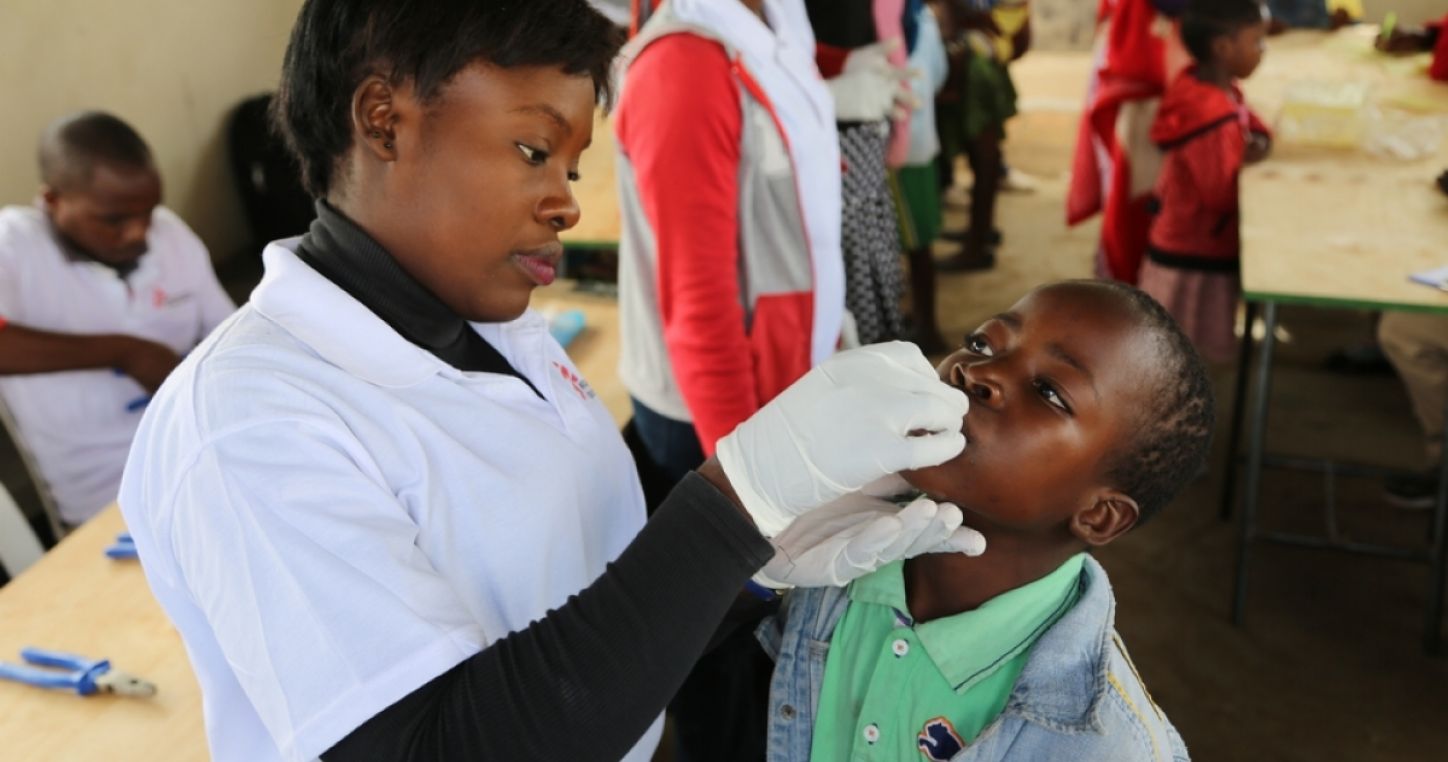 A member of the MSF vaccination team provides a single dose of the oral cholera vaccine to a boy in Self Help Center in Lusaka. Photo: Laurence Hoenig/MSF